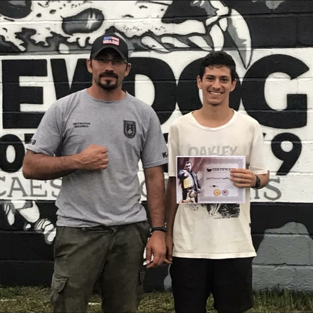 João receiving his dog training certificate from instructor Ricardo at New Dog in 2020